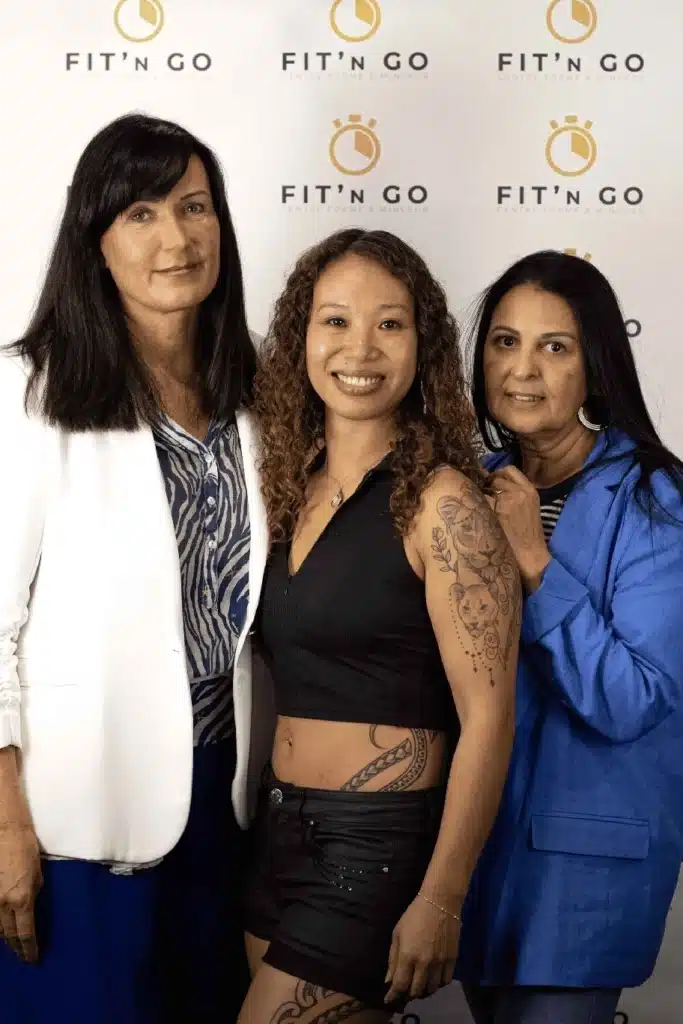 Trois femmes souriantes devant le logo Fit'n Go Centre Forme & Minceur, posant de manière professionnelle.